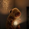 Peluche Capibara Soñadora con Proyector de estrellas y Música.